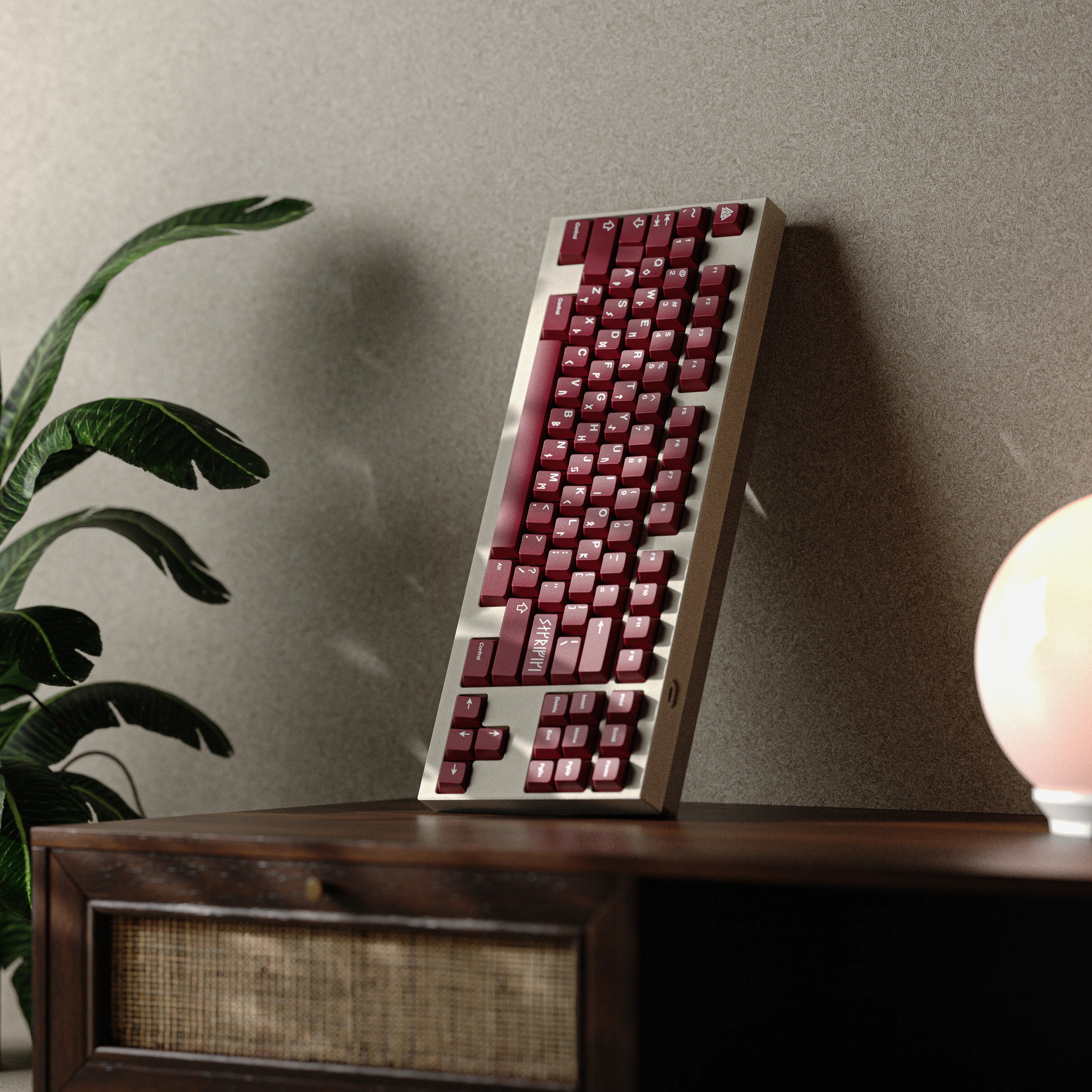 Mechanical keyboard with red keys on a wooden surface against a neutral wall.