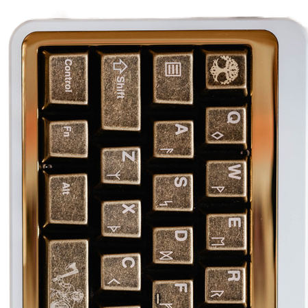 A set of metal keycaps with a gold plating, featuring Viking-themed embossed designs.